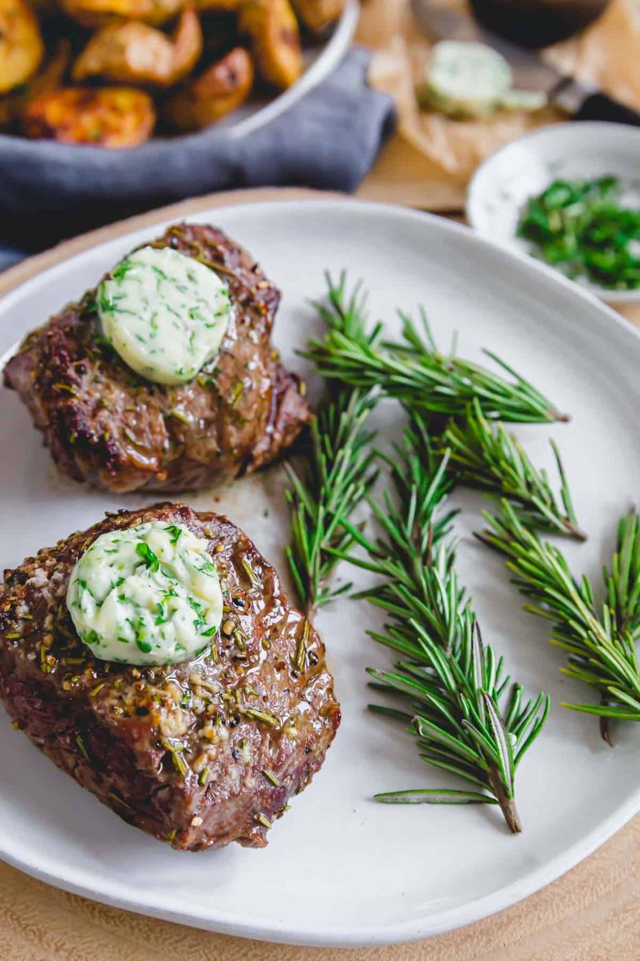 Filet mignon cooked in the air fryer topped with herbed compound butter.