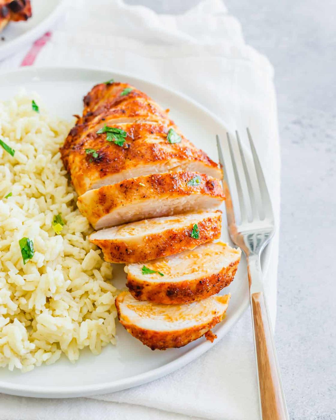 Air fryer frozen chicken breast recipe with simple seasoning served on a plate with rice.