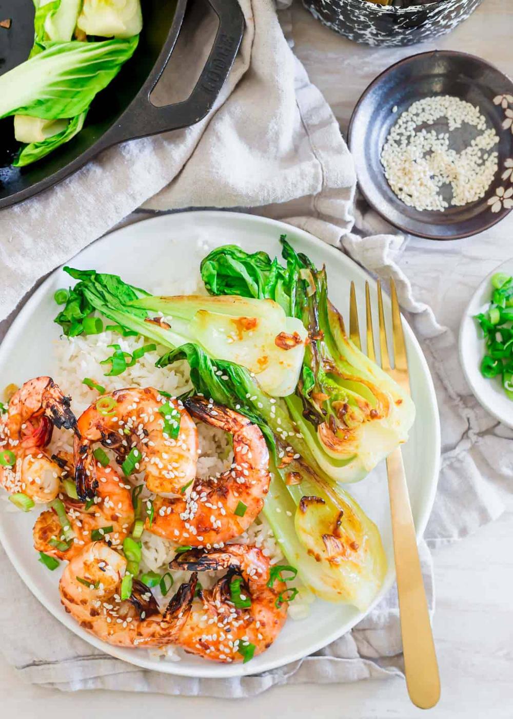 Frozen wild caught large shrimp made in the air fryer on a plate with white rice and baby bok choy.