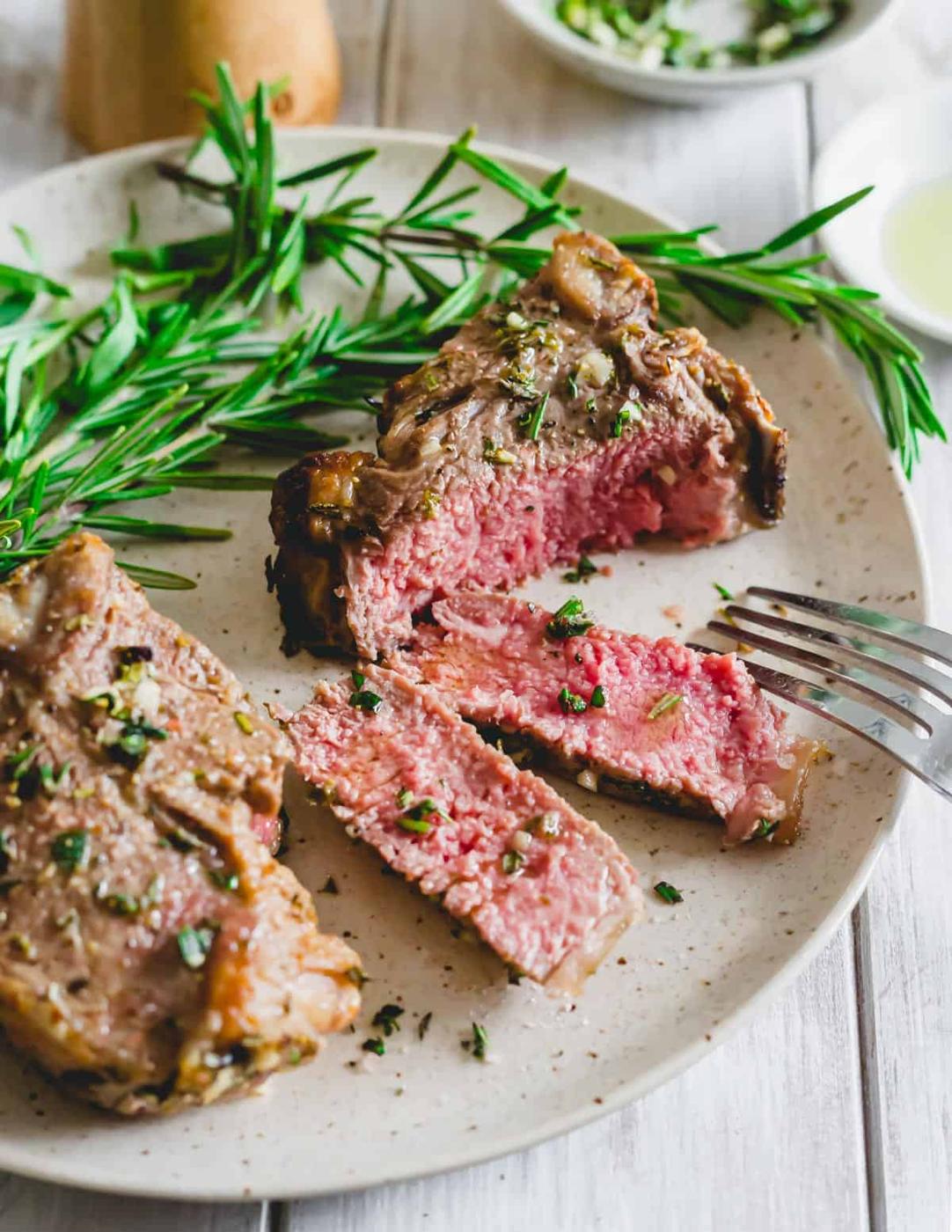 Sliced air fried lamb loin chop on a plate with a fork.