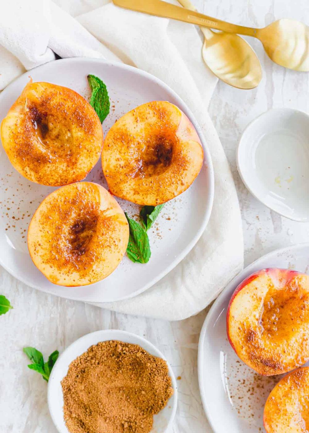 Cinnamon sugar coated peach halves on a plate.