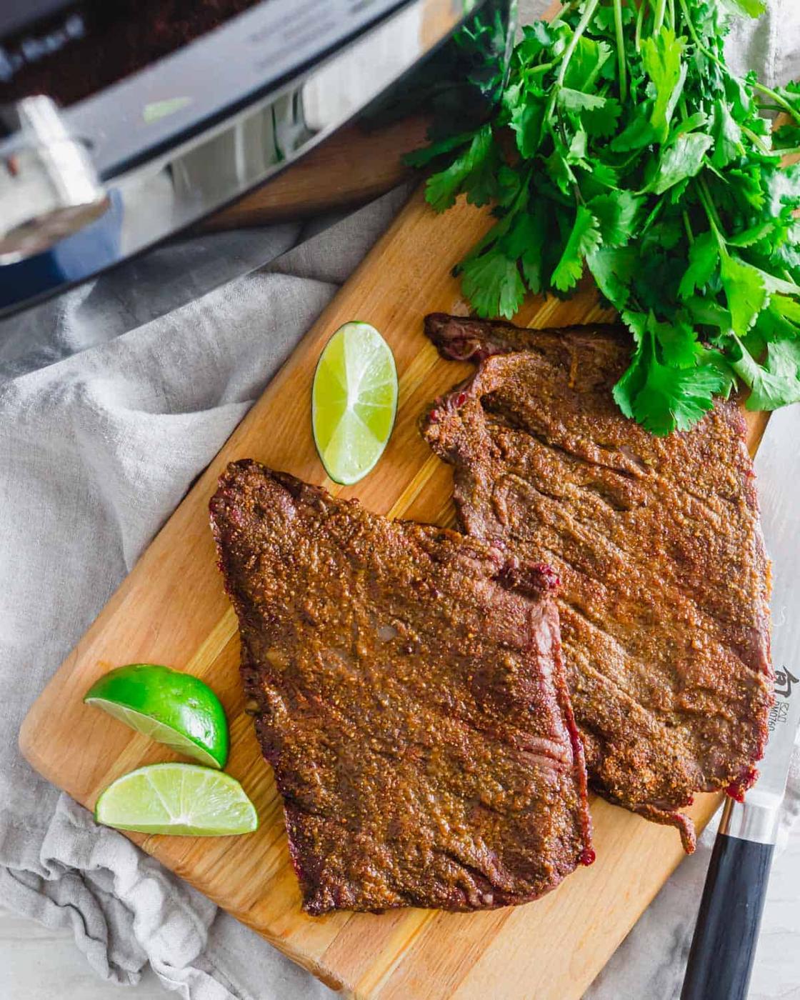 Air fried skirt steak on a cutting board before being sliced.
