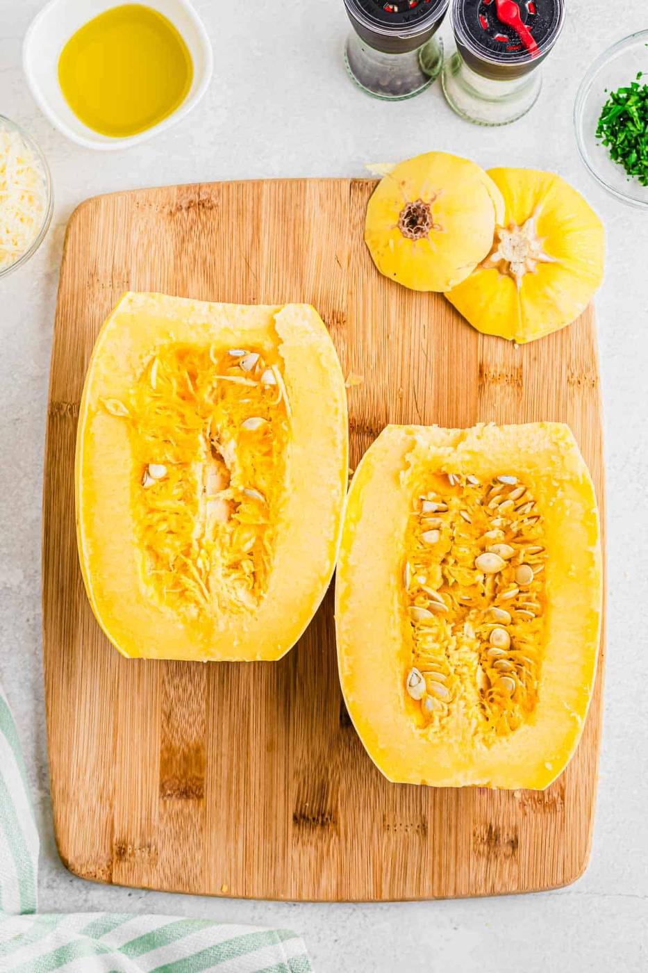 Spaghetti squash sliced in half on a wooden cutting board.