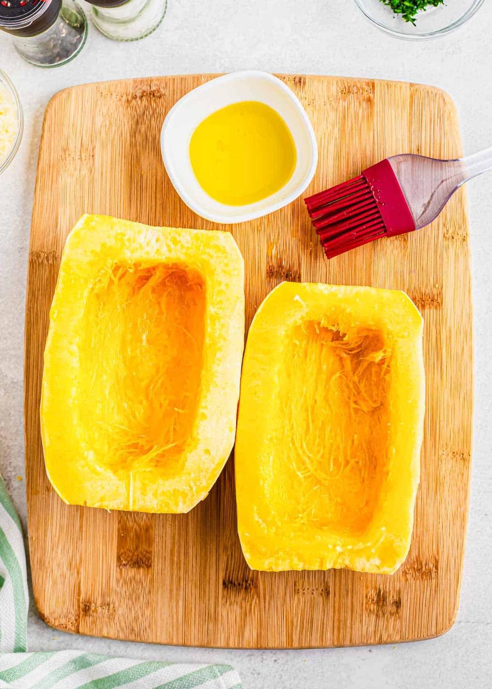 Brushing spaghetti squash halves with olive oil.