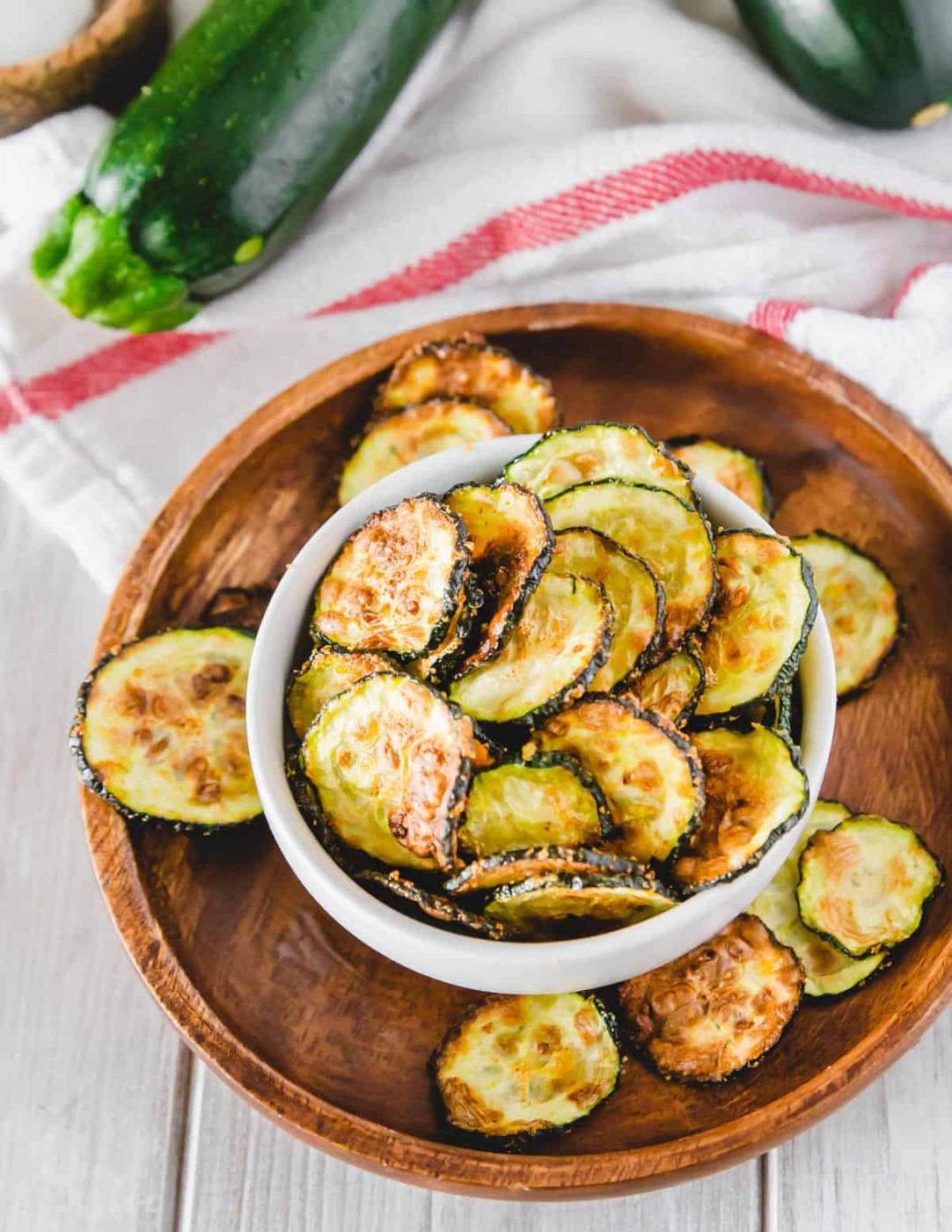 Air fryer zucchini chips with no breading in a serving bowl on a plate.