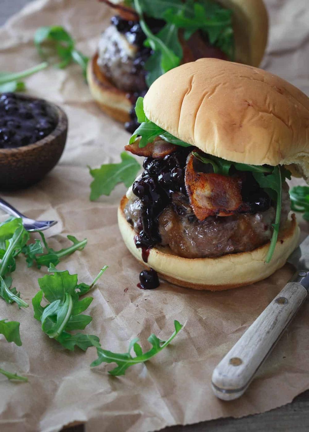 This brie burger is topped with a sweet and tangy blueberry BBQ sauce, crispy bacon and fresh arugula.