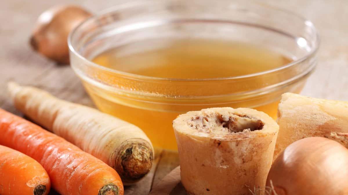 A bowl of broth and carrots next to a bowl of broth.