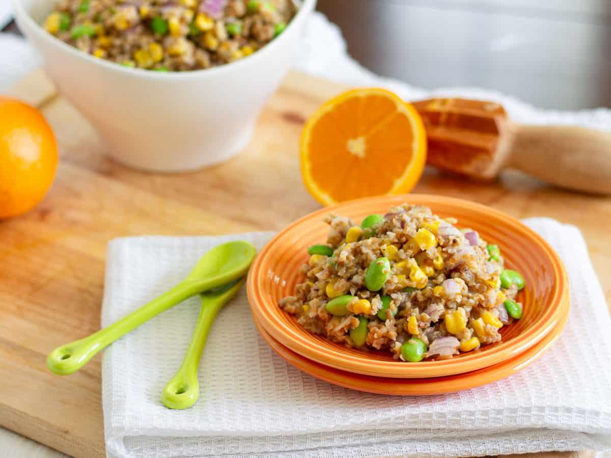 Bulgur wheat salad on two stacked orange plates.