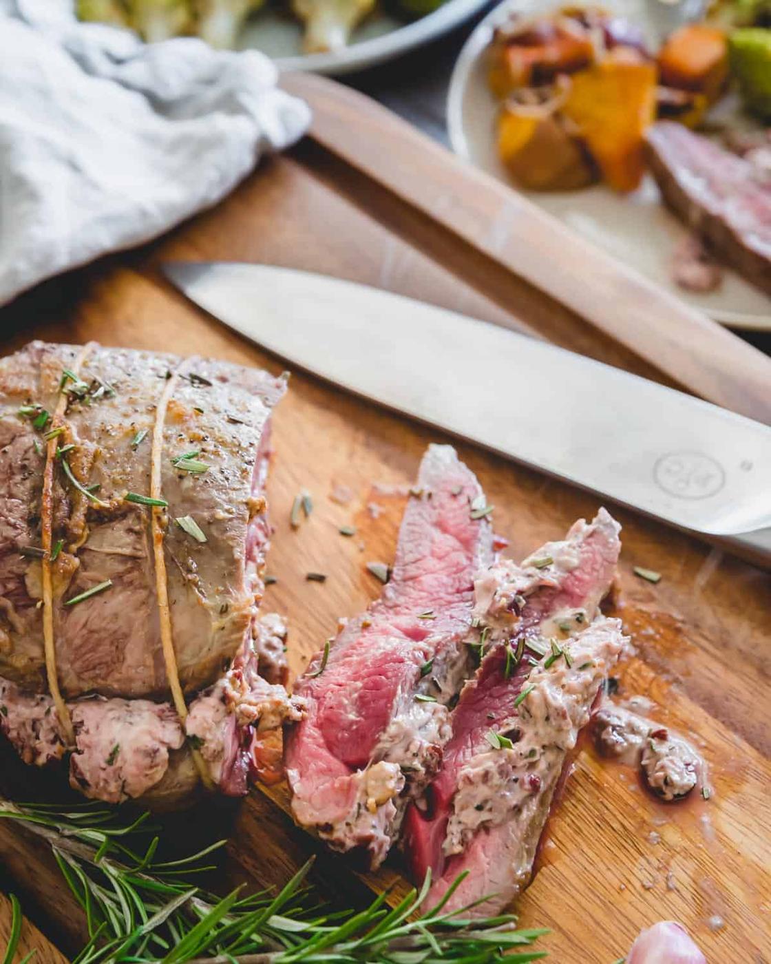 Cranberry goat cheese stuffed boneless leg of lamb that's been butterflied and roasted in the oven
