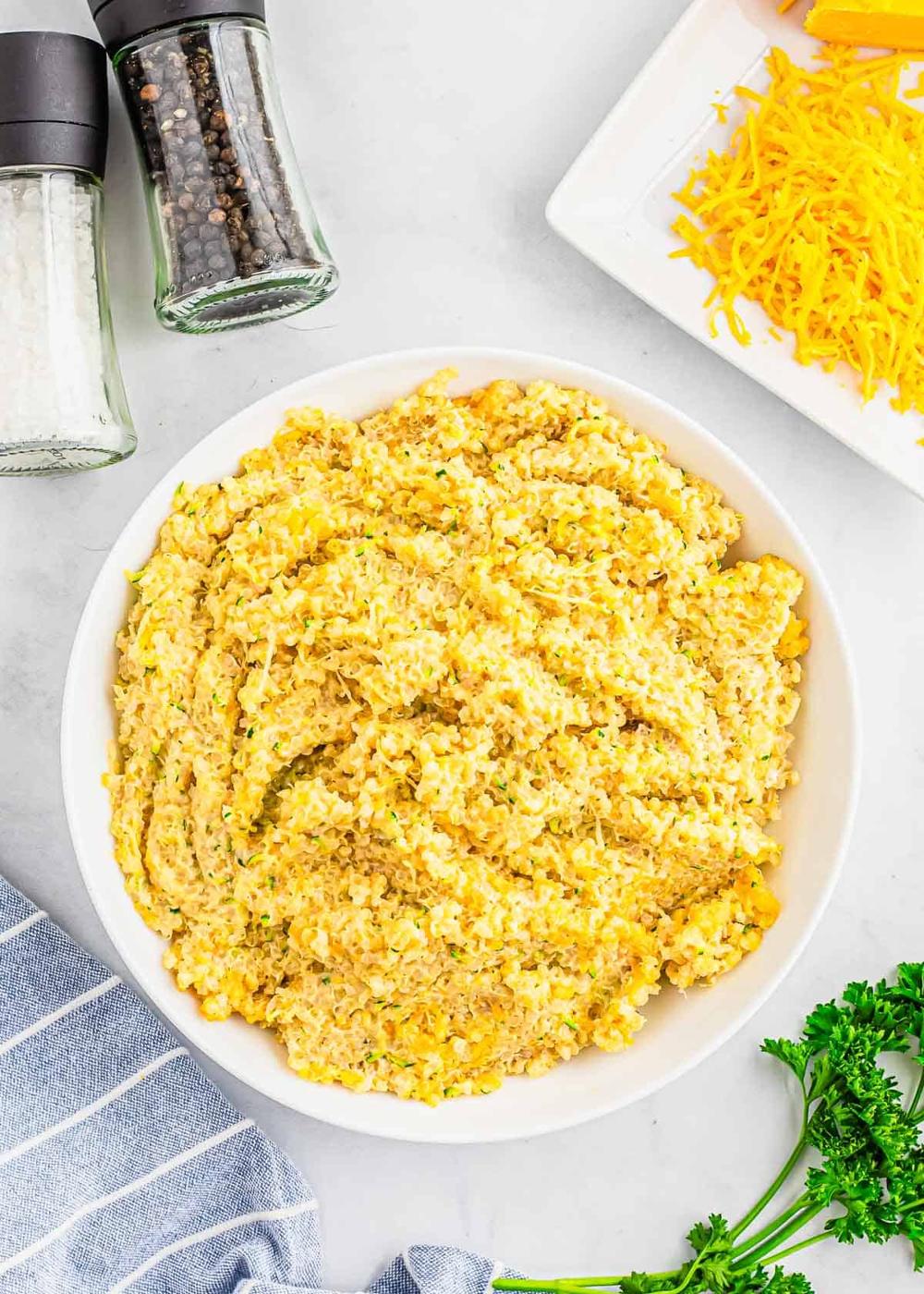 A bowl of cheesy quinoa with parsley.