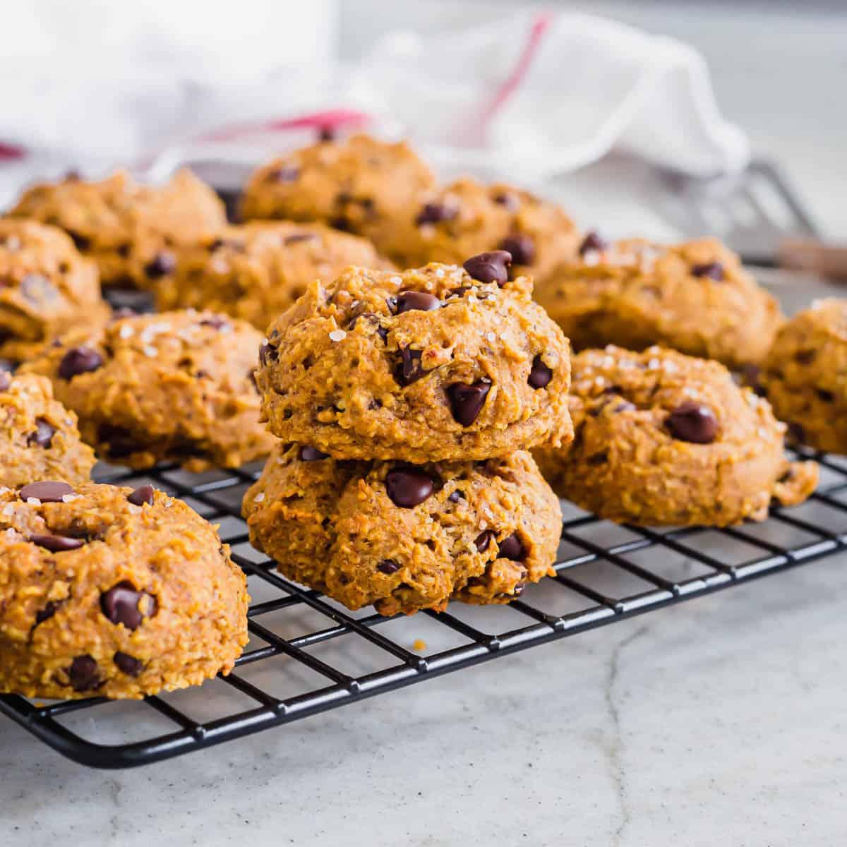 Chewy pumpkin cookies stacked on a cooling rack.