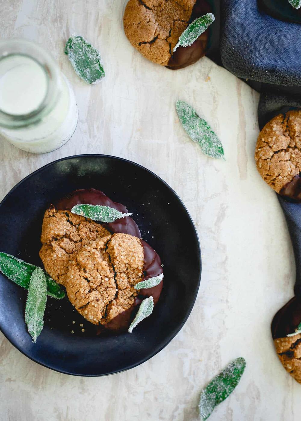 These flourless cashew almond butter cookies are dipped in dark chocolate and garnished with candied sage. They're a fun chewy winter treat!