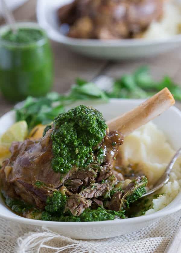 These citrus braised lamb shanks are served with a spicy green harissa.