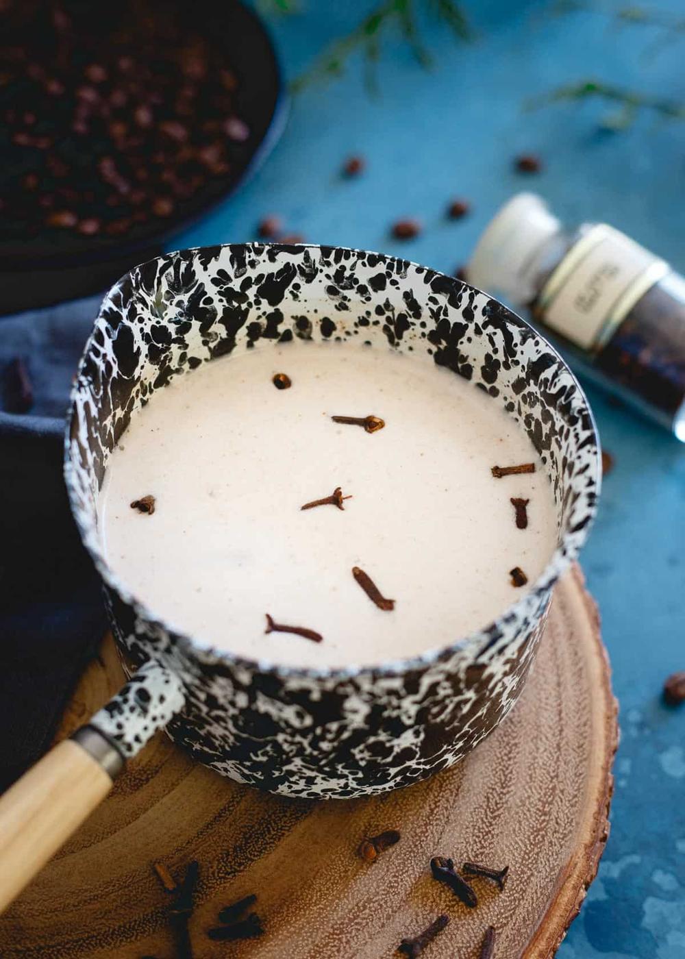 Spiced coconut milk makes the perfect cozy winter addition to some bourbon and coffee for this festive drink!