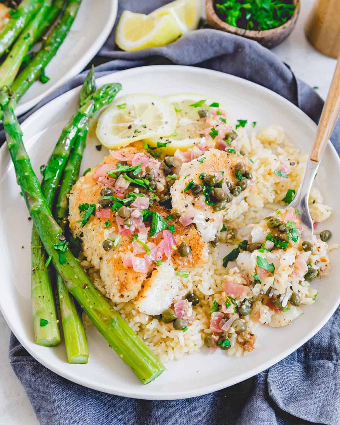 Gluten free cod piccata on a plate with a fork.