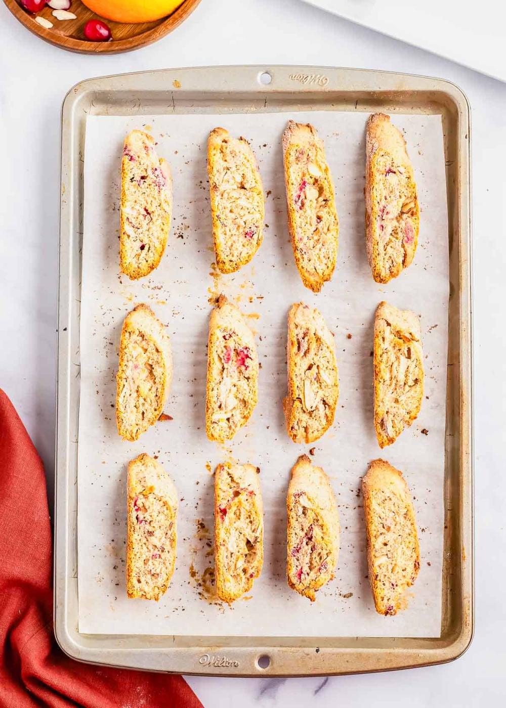 Cranberry orange biscotti cookies on a baking sheet after baking.