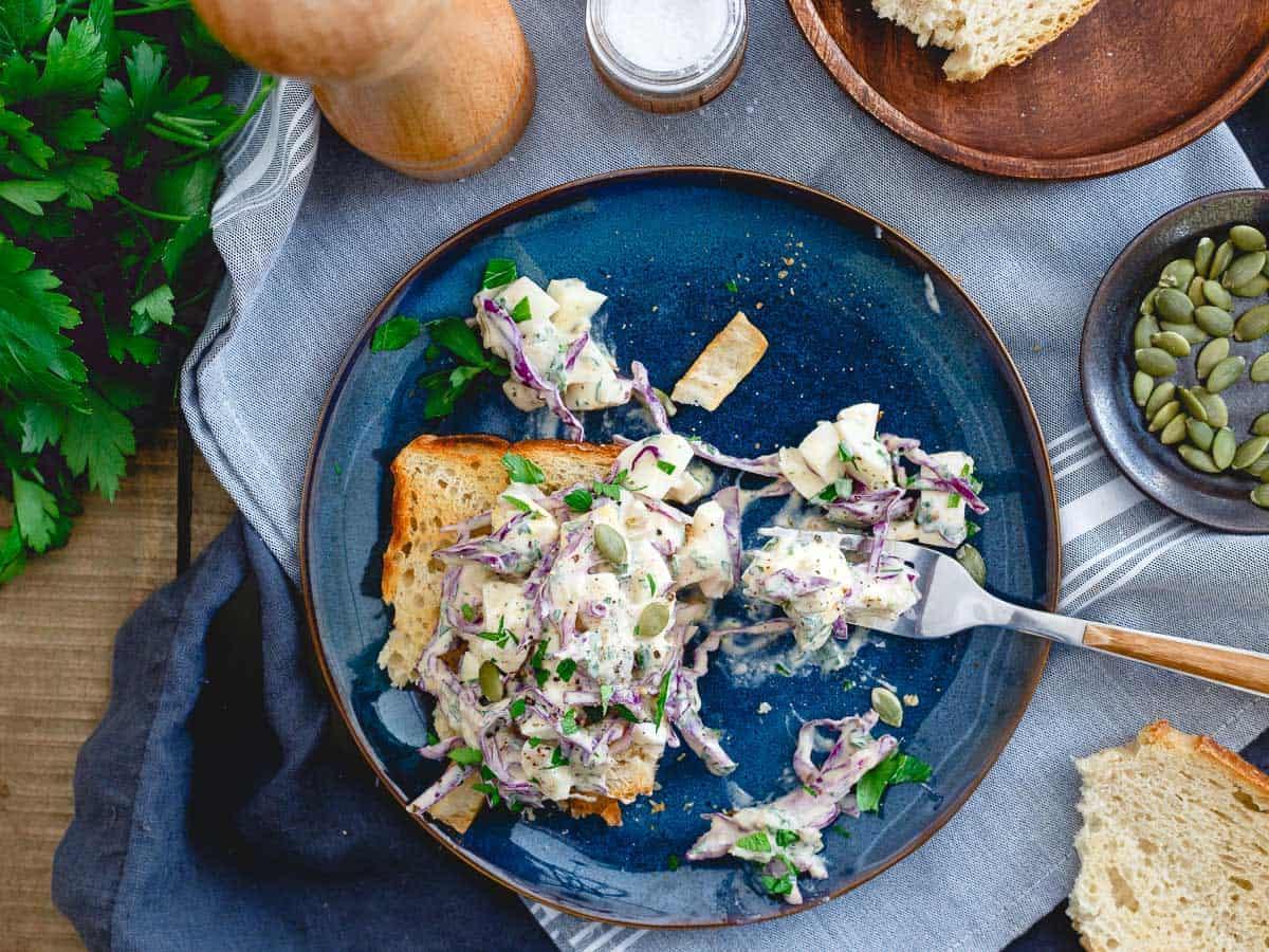 top shot of a healthy egg salad sandwich made with greek yogurt, mustard, and olives