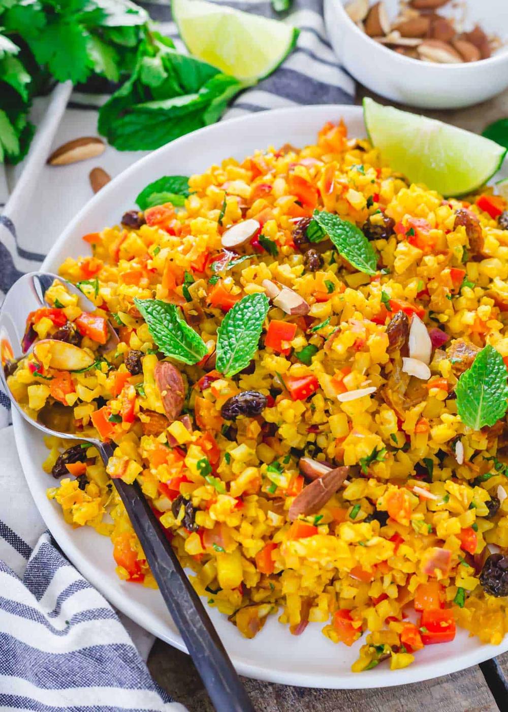 Close up of serving spoon in a dish of curried cauliflower rice.