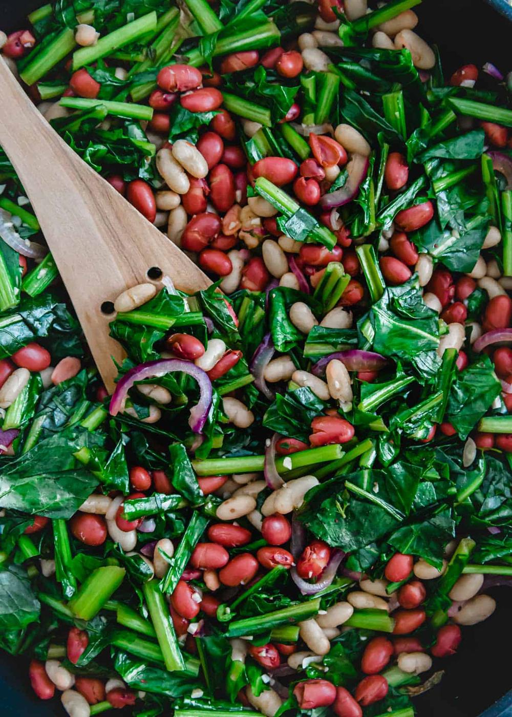 Red onion, cannellini beans, red beans and dandelion greens are sautéed together for an easy vegetarian skillet meal.