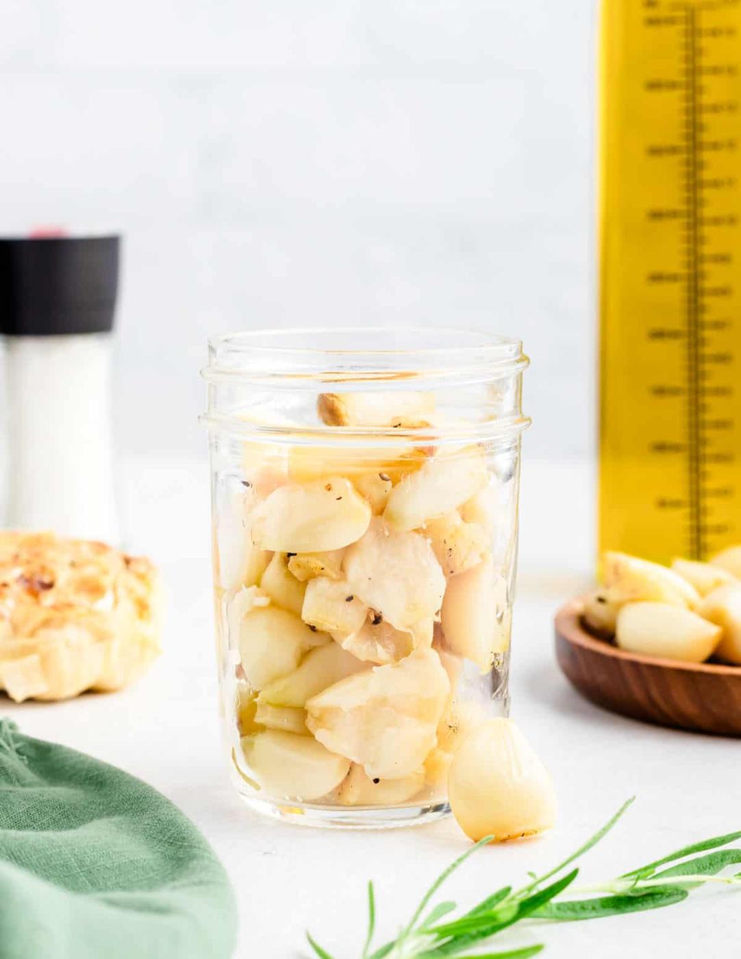 Air fryer roasted garlic cloves in a small glass jar.