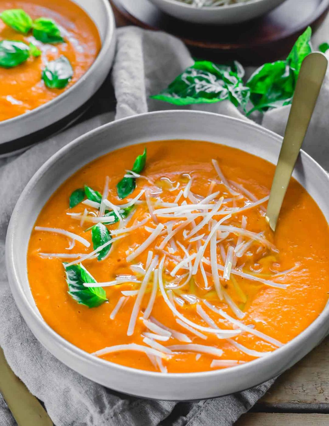 Roasted garlic tomato soup in a bowl drizzled with olive oil.