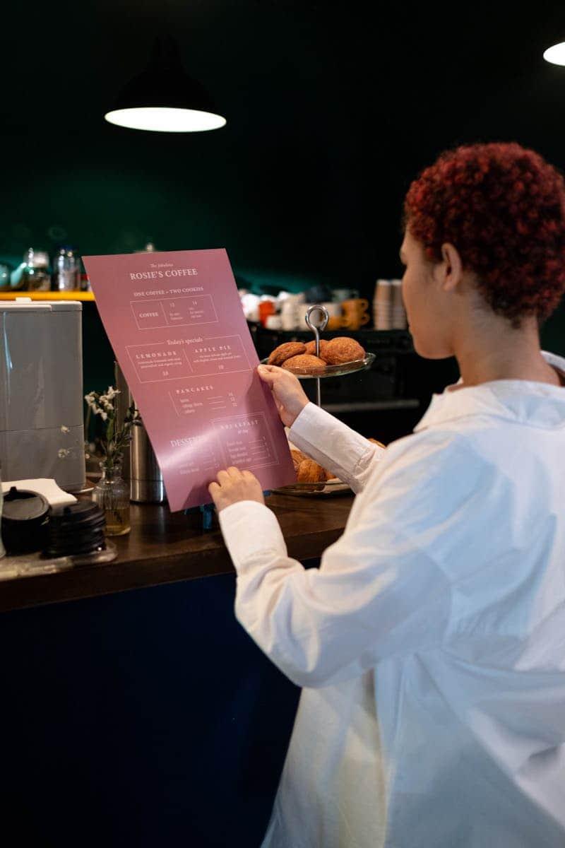 A woman looking at a gluten-free menu in a coffee shop.