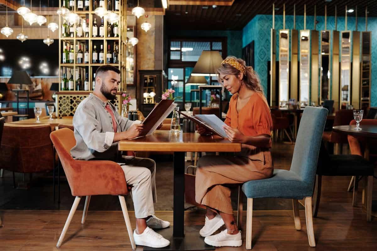 A man and a woman looking at the restaurant menu.