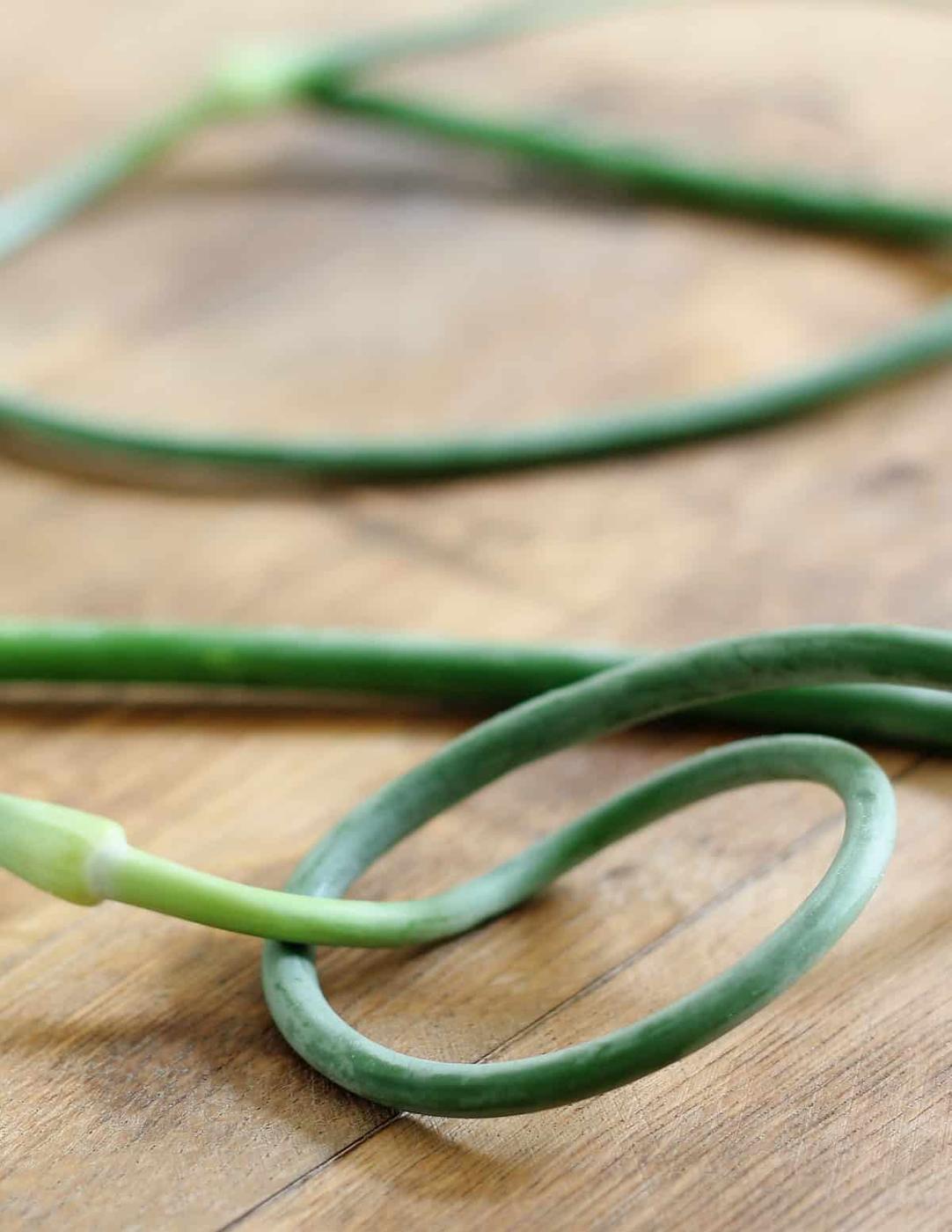 Garlic scapes on wooden board.