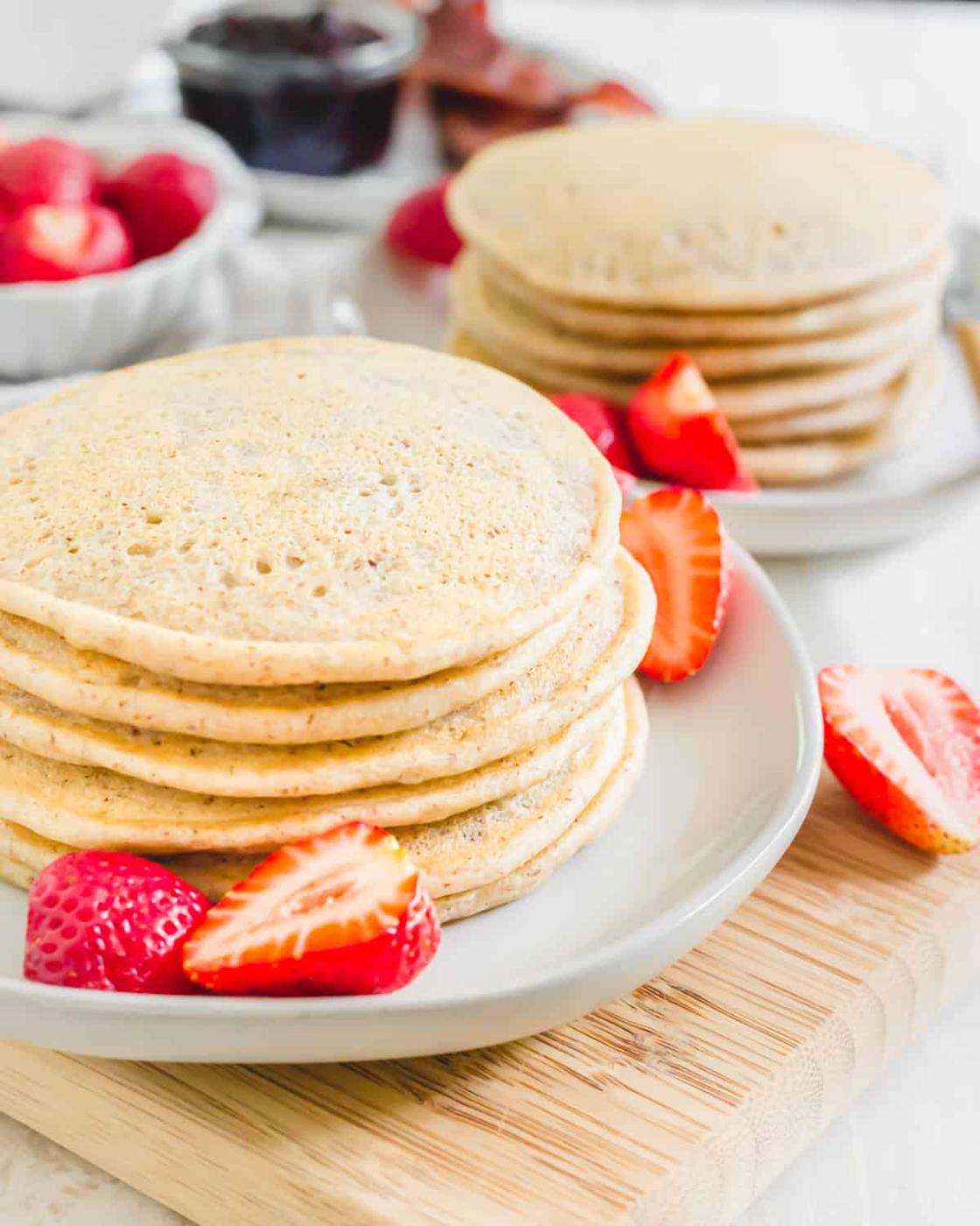 Stack of cassava flour pancakes with strawberries on a plate.