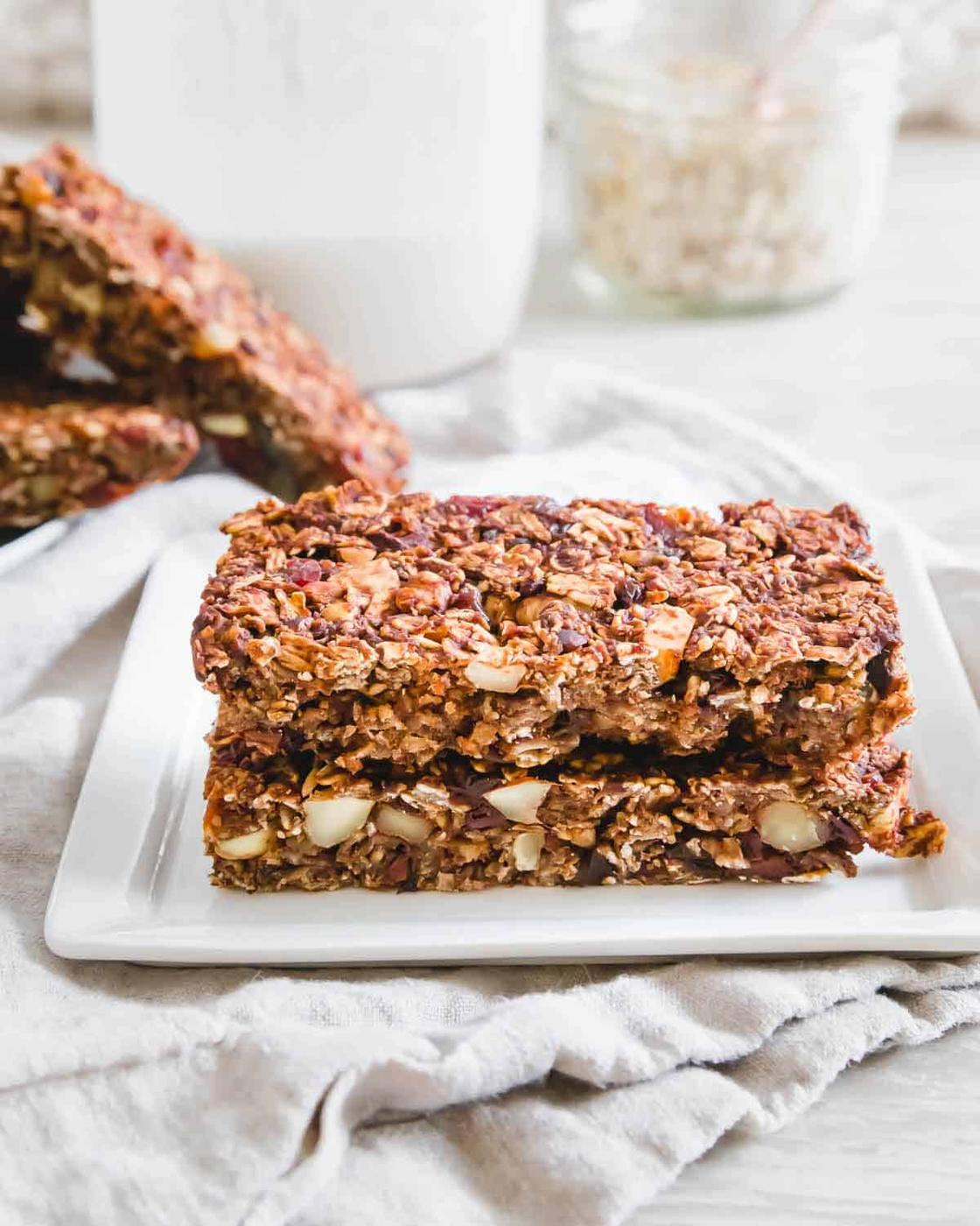 Chocolate granola bars stacked on a white plate.
