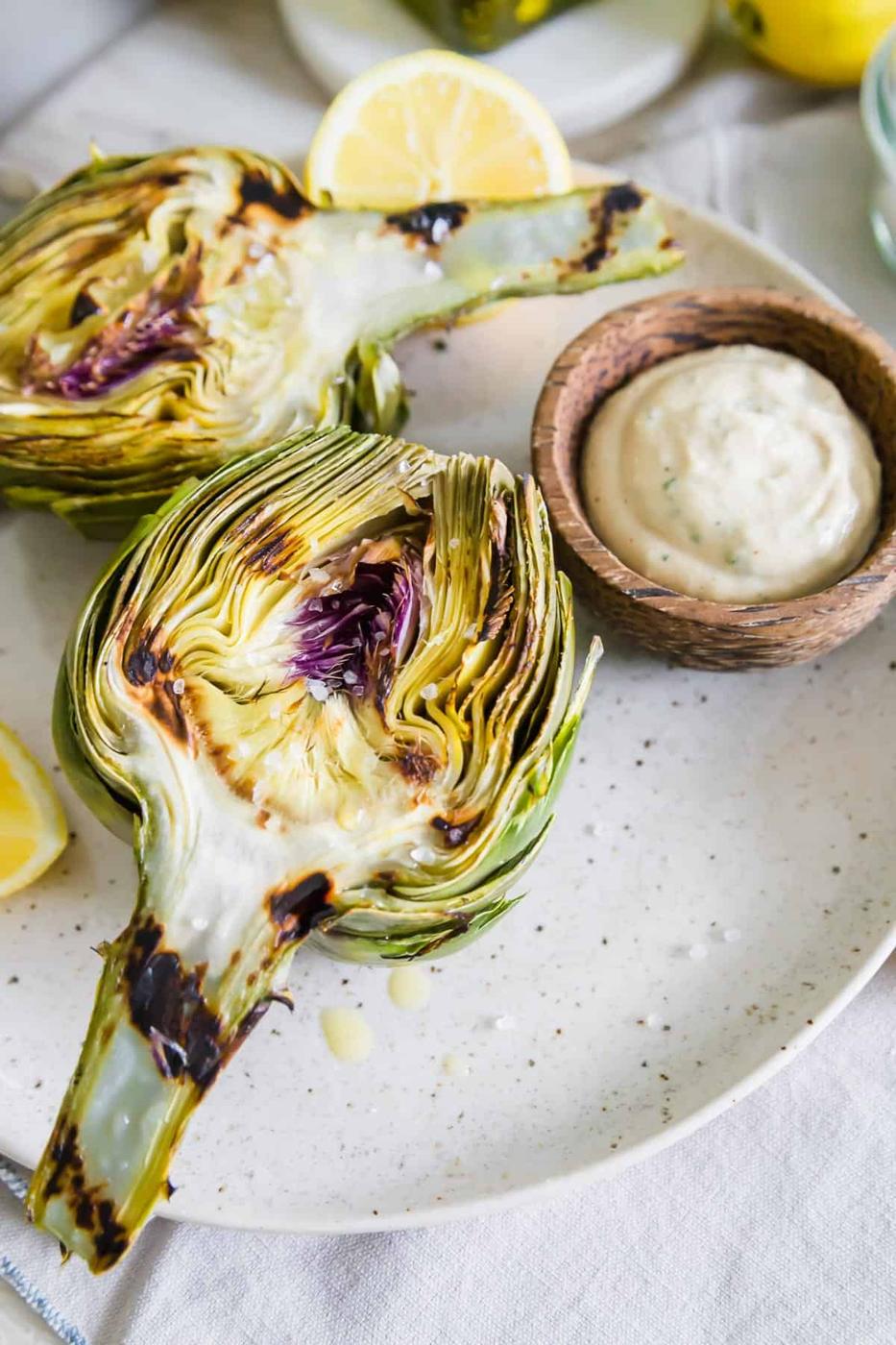 Enjoy these easy grilled artichokes with a drizzle of olive oil, sea salt and bright tahini lemon herb dipping sauce.