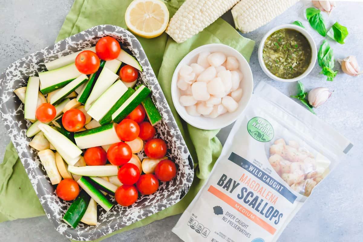 Frozen bay scallops are tossed in a garlic basil butter sauce and grilled with summer vegetables for an easy meal.