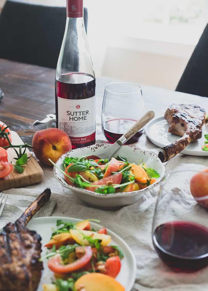 Sutter Home Sweet Red wine goes perfectly with these harissa rubbed grilled pork chops and tomato peach salad.