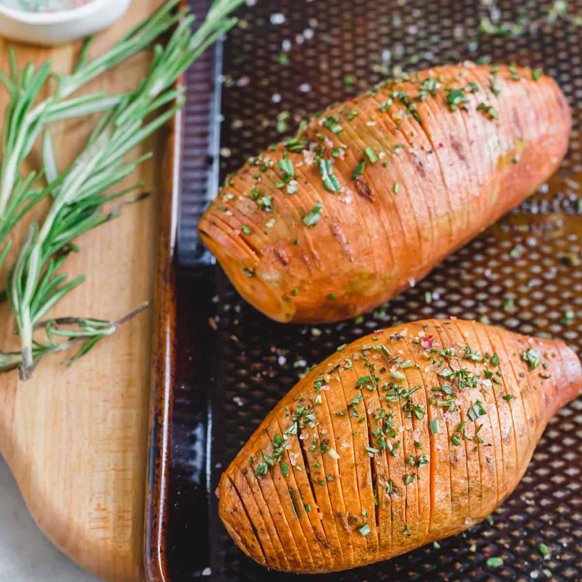 Hasselback sweet potatoes on a baking sheet ready to be roasted.