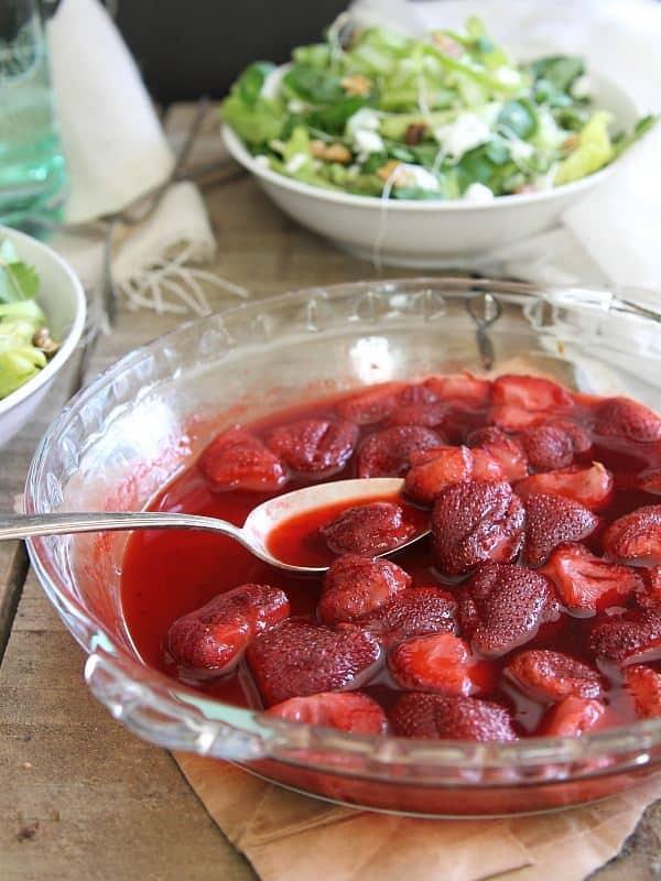 Roasted strawberries next to a bowl of salad.