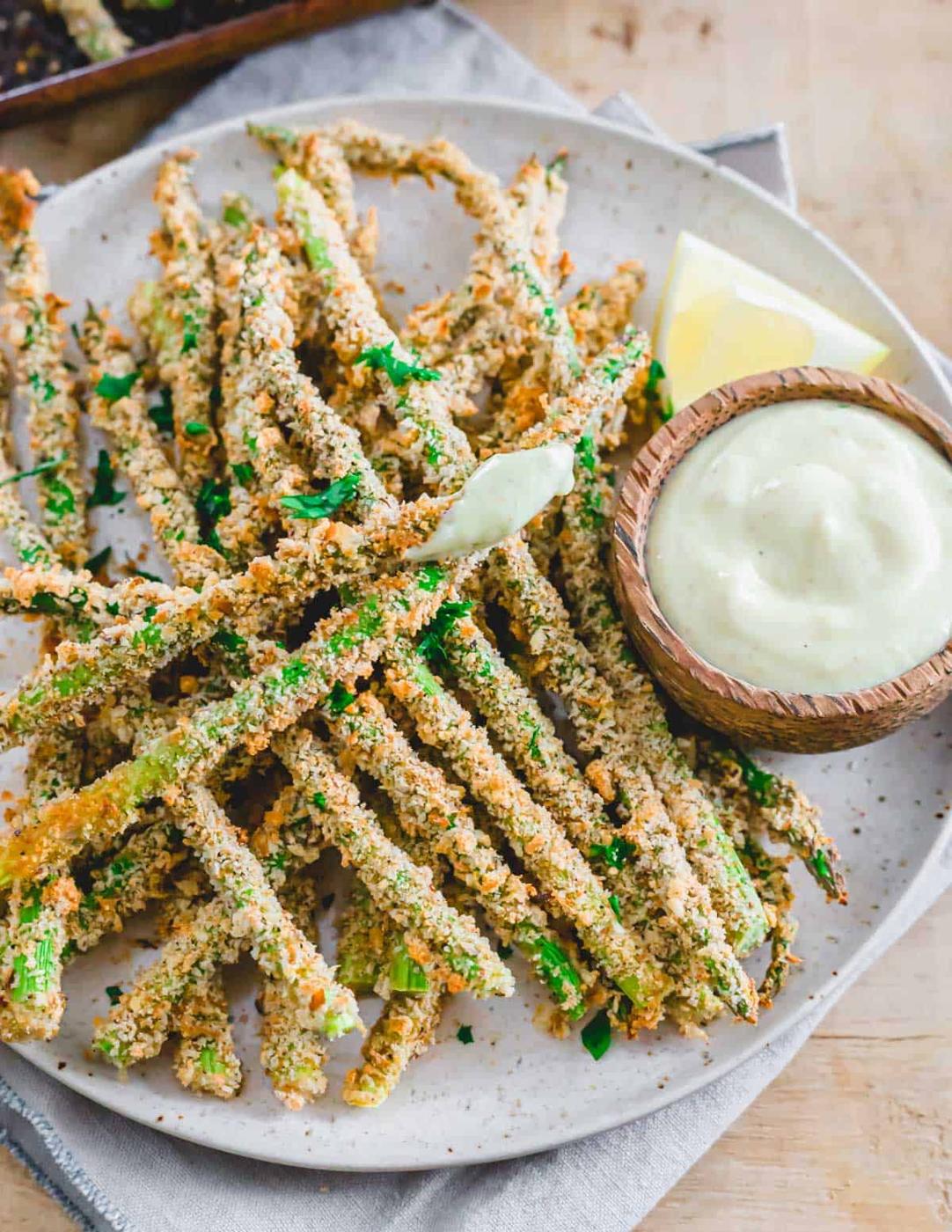 Asparagus fries on a plate with dipping sauce.
