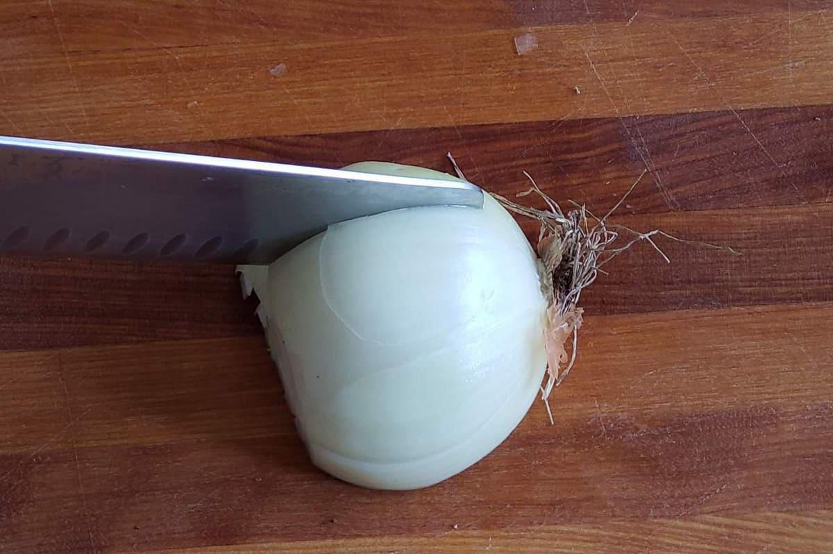 Making slits in an onion with a knife.