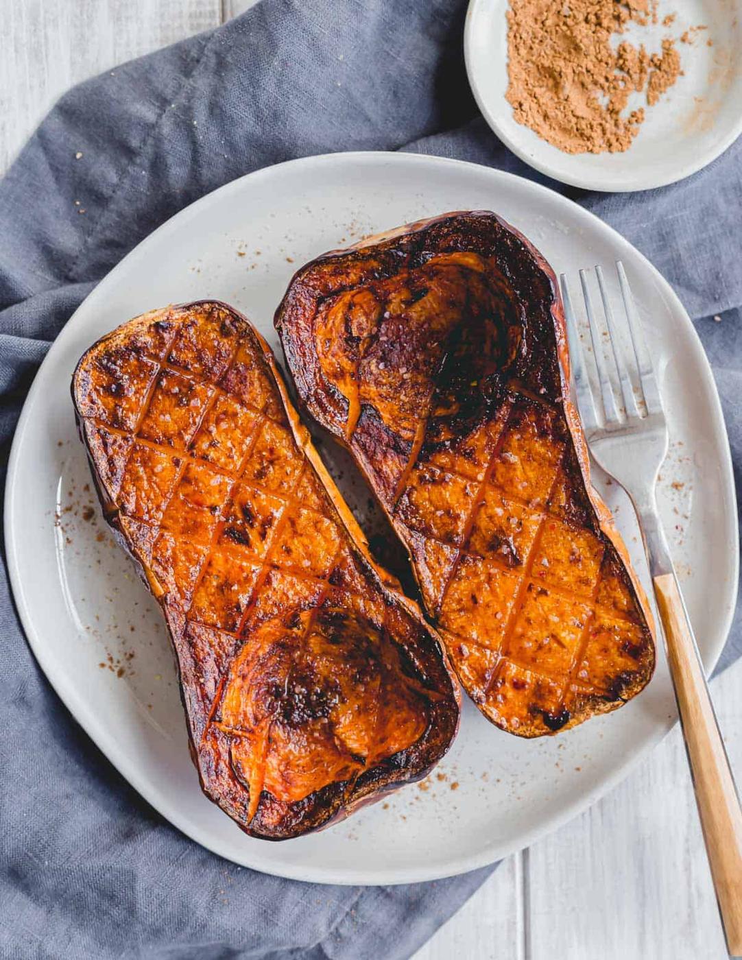 Butternut squash roasted in the air fryer with Chinese 5 spice powder, salt and ghee on a plate with a serving fork.