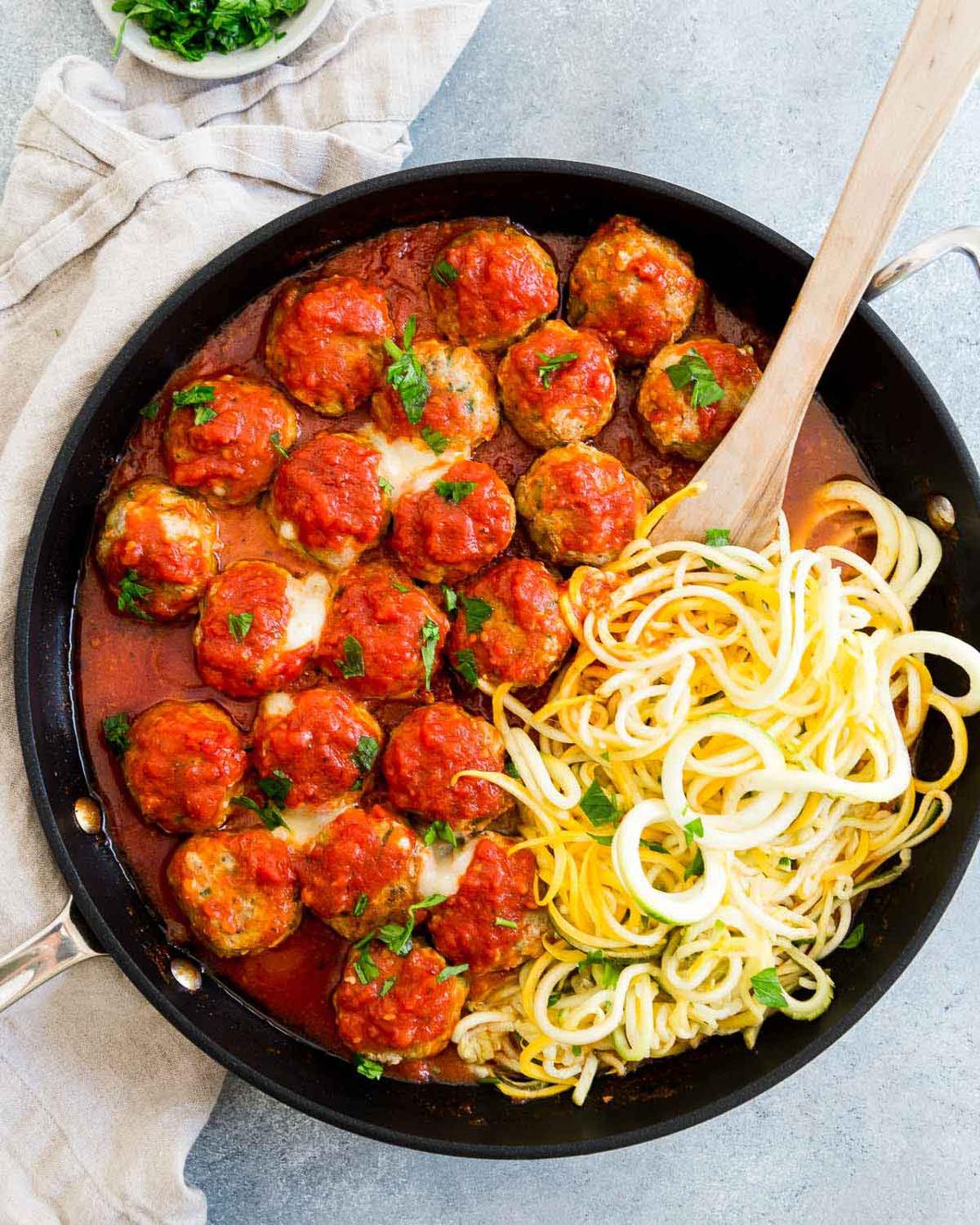 Zucchini noodles in a pan with turkey meatballs.