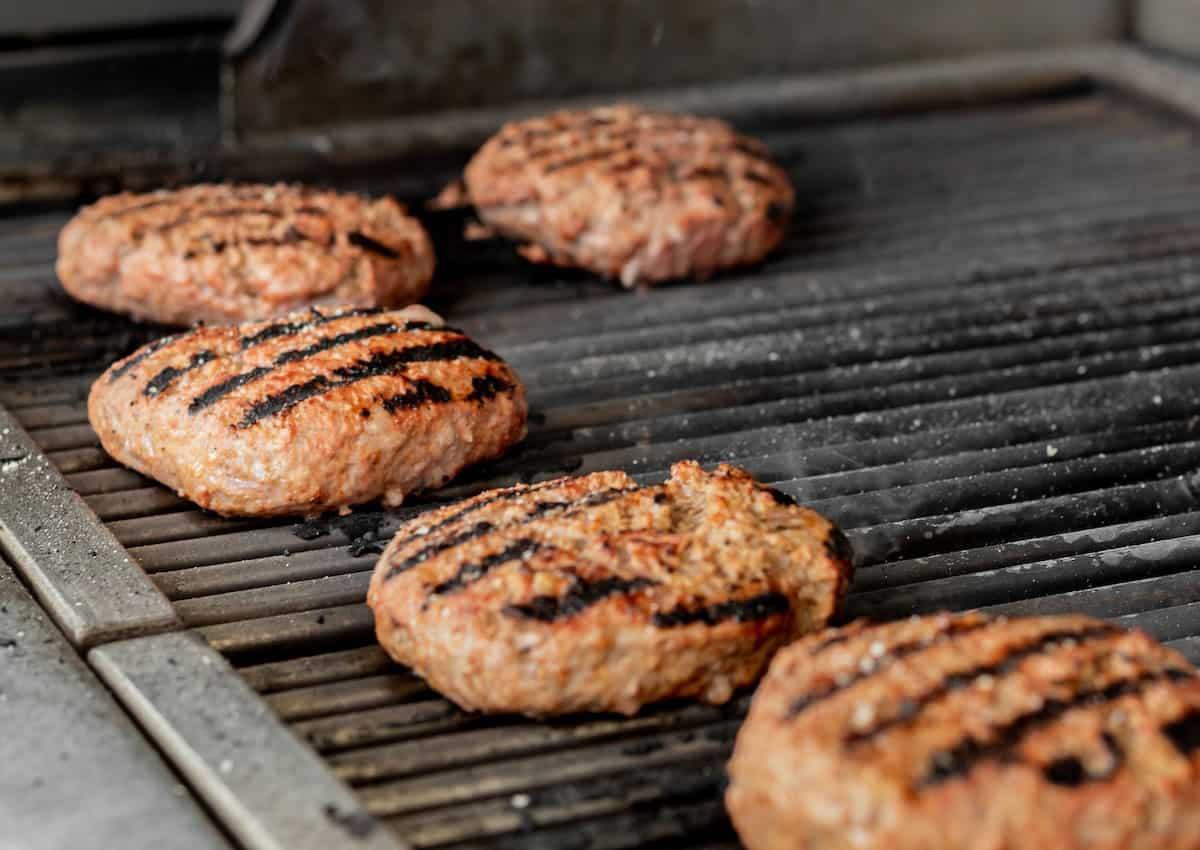 Burger patties on grill grates.