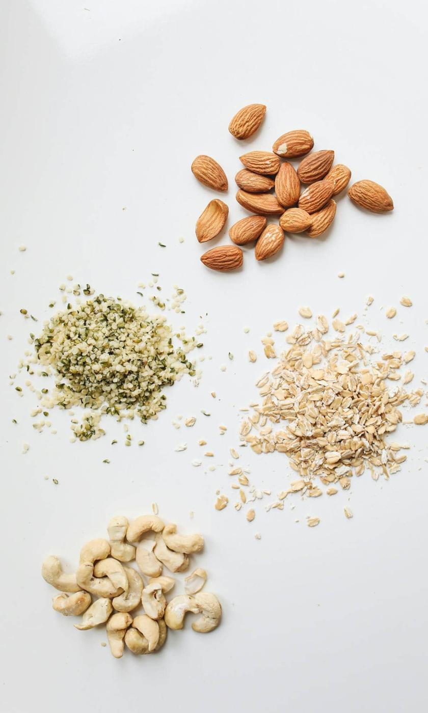 A variety of nuts and seeds on a white surface.