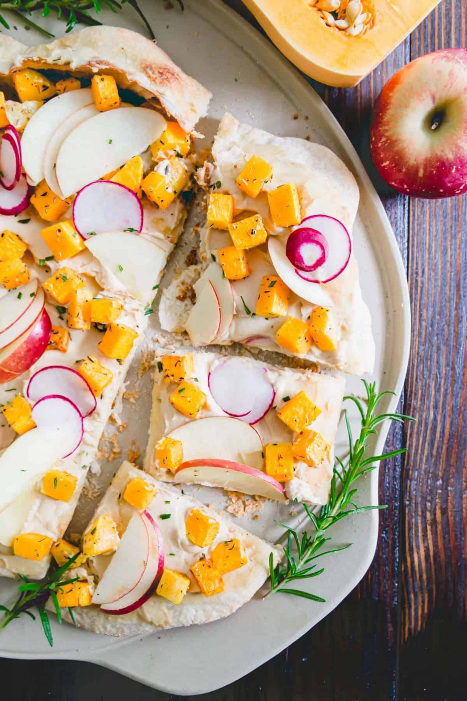 Try hummus pizza for a non-dairy twist to pizza night. This one is topped with roasted butternut squash, apples and radishes.
