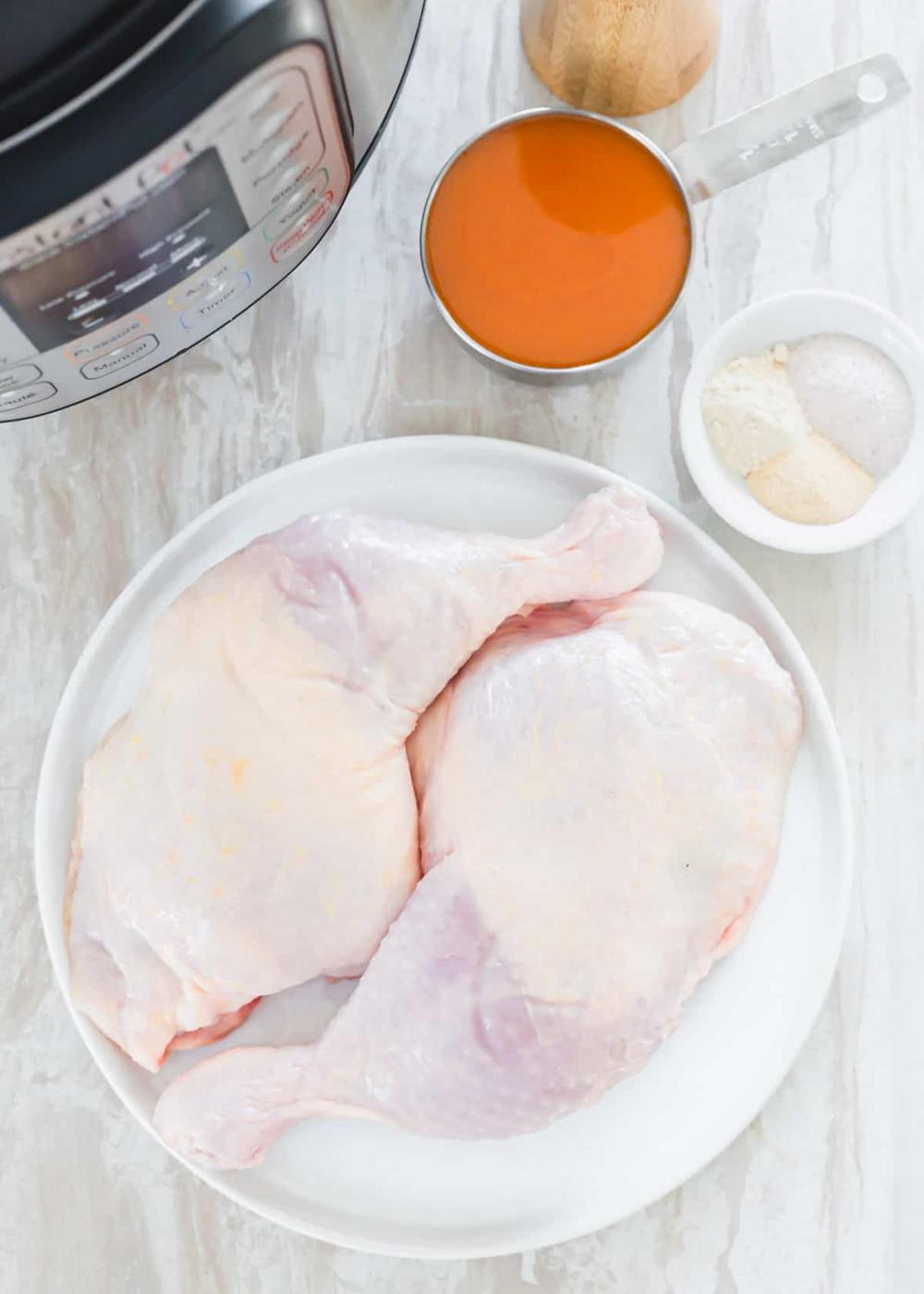 Ingredients to make chicken leg quarters in the Instant Pot: 2 chicken legs, buffalo sauce and spices.