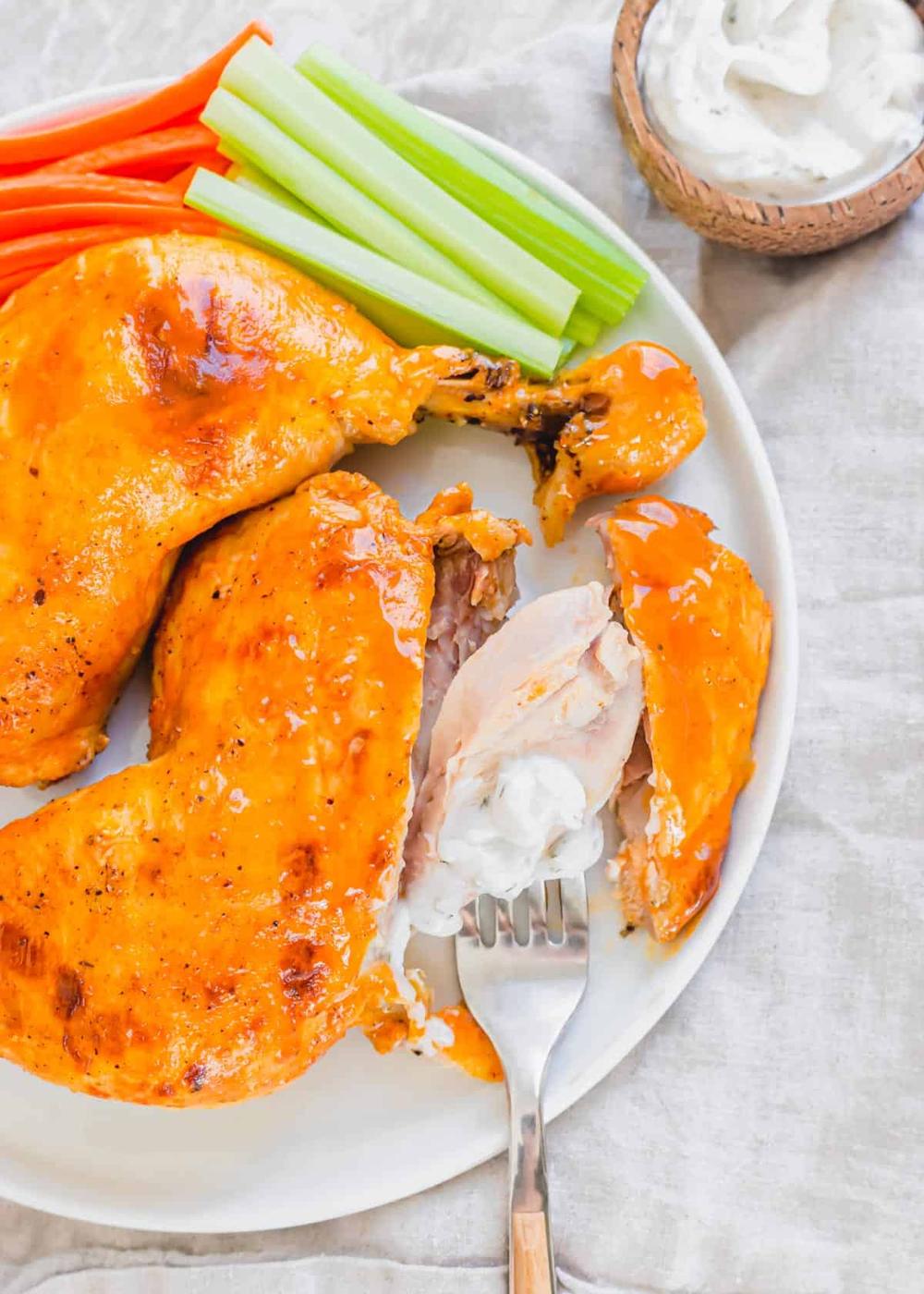 Chicken leg meat on a fork with ranch dipping sauce.