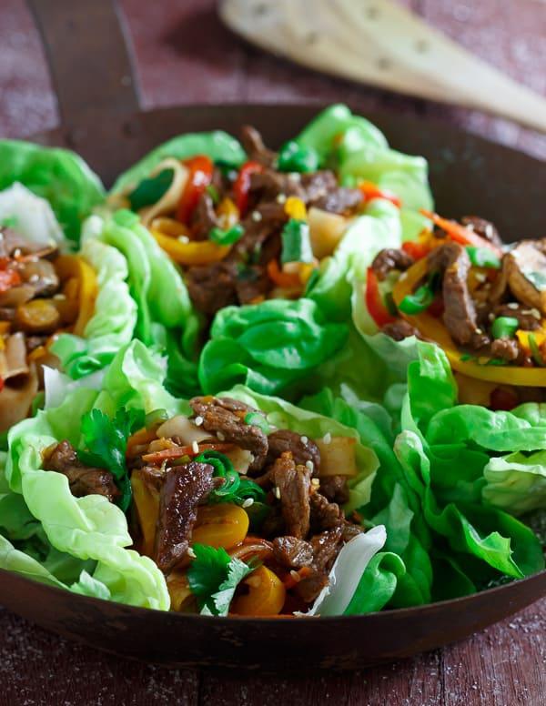 Sticky sweet Korean style steak is tossed with peppers, carrots, green onions, rice noodles and served in crispy lettuce cups.