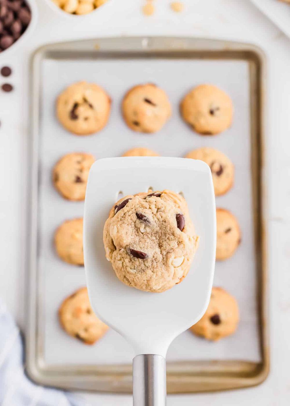 A chocolate chip macadamia nut cookie on a rubber spatula.