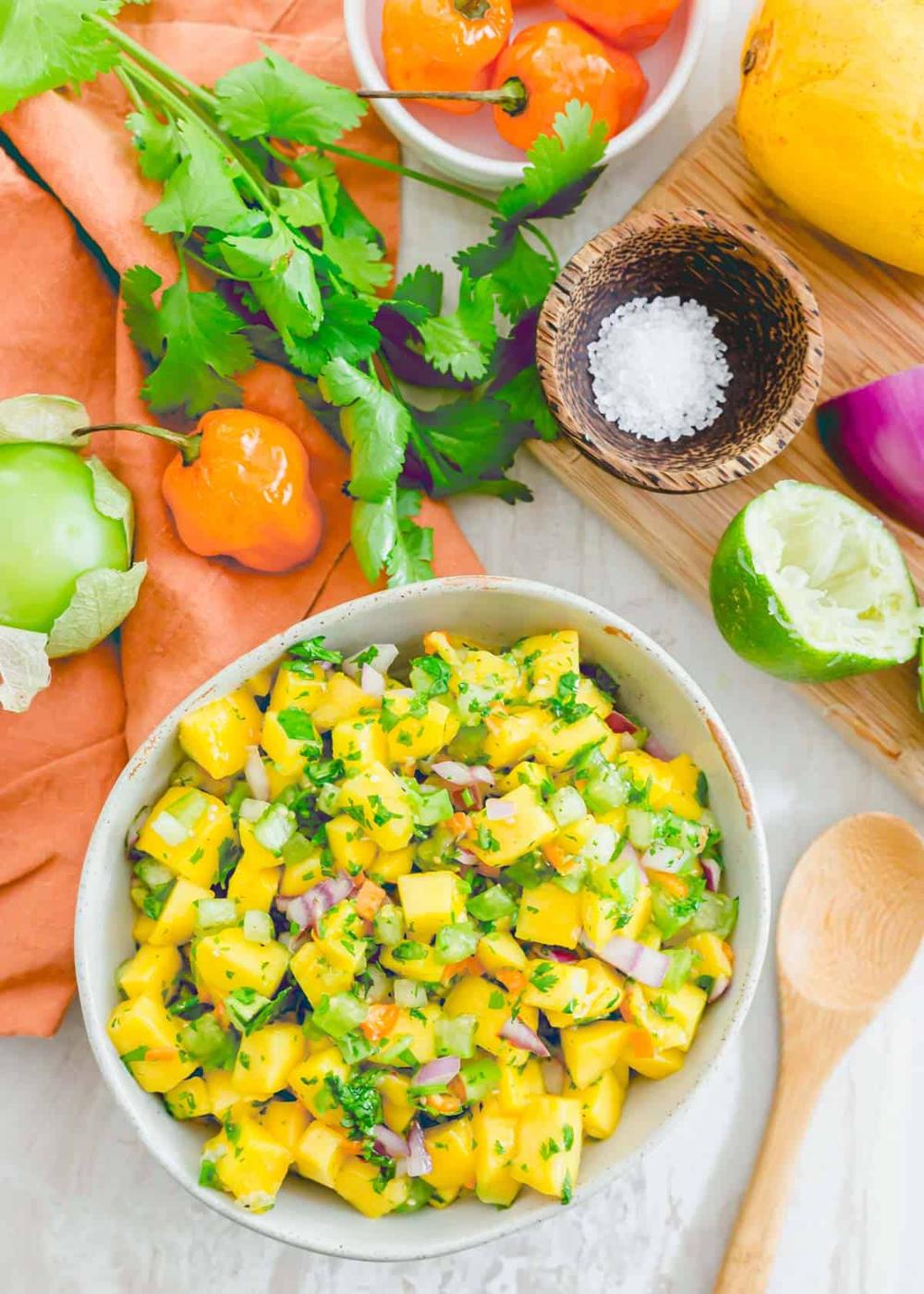 Freshly made mango habanero salsa in a bowl with a serving spoon on the side.