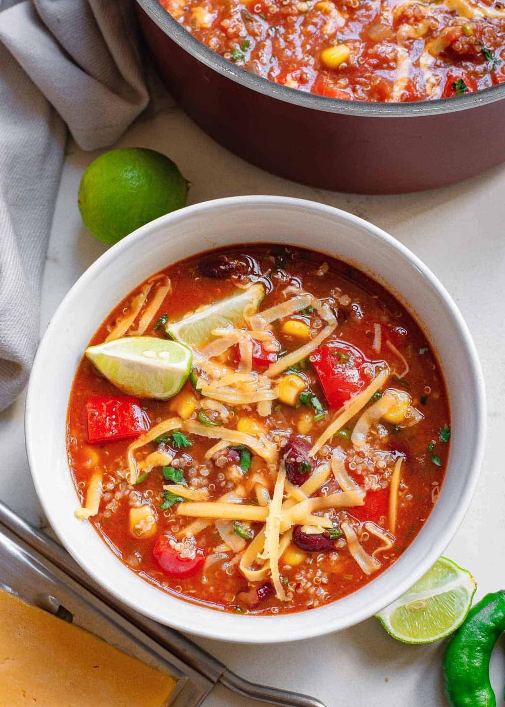 Gluten-free vegetarian Mexican vegetable soup recipe with beans and quinoa in a white serving bowl.