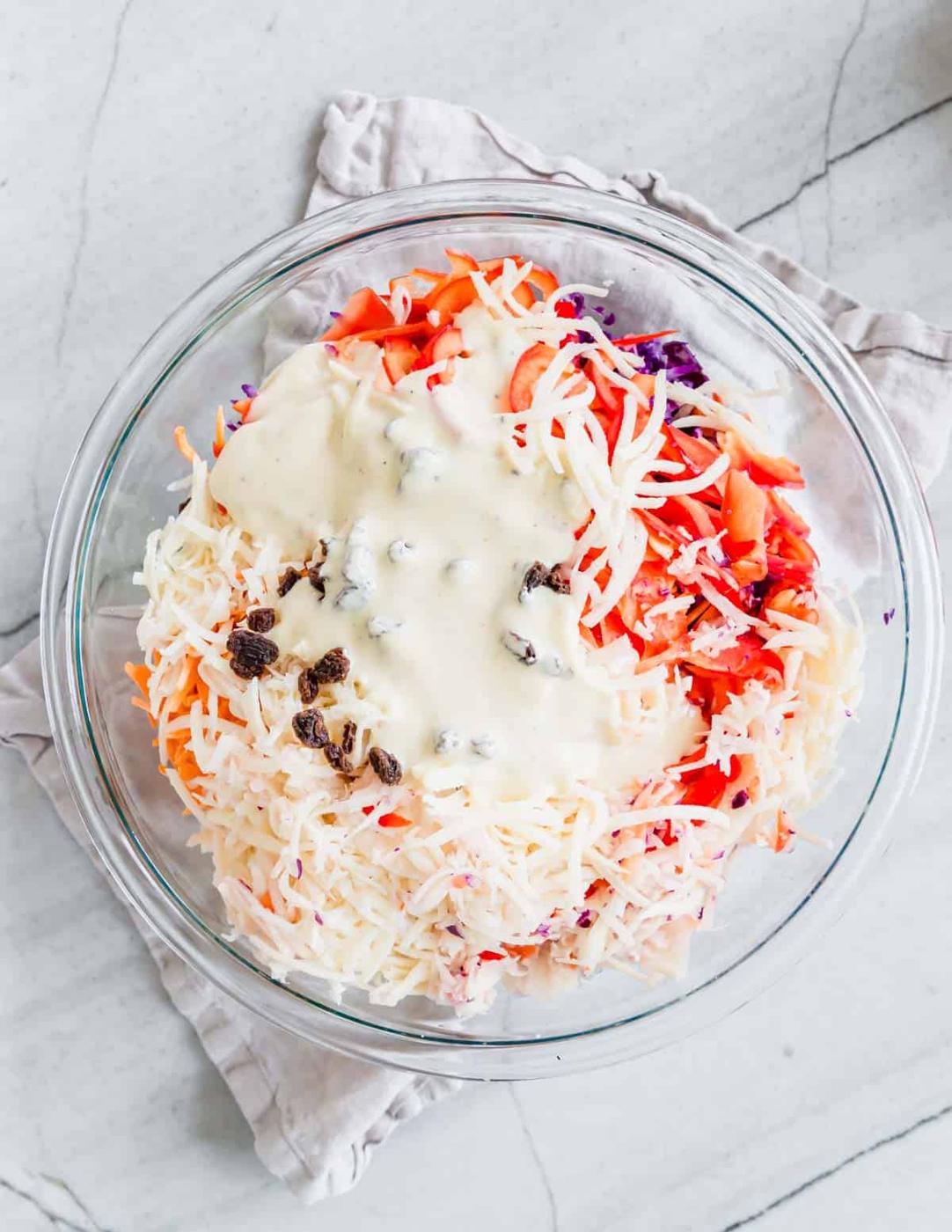 Overhead shot of Irish coleslaw in a glass bowl with dressing poured on top.