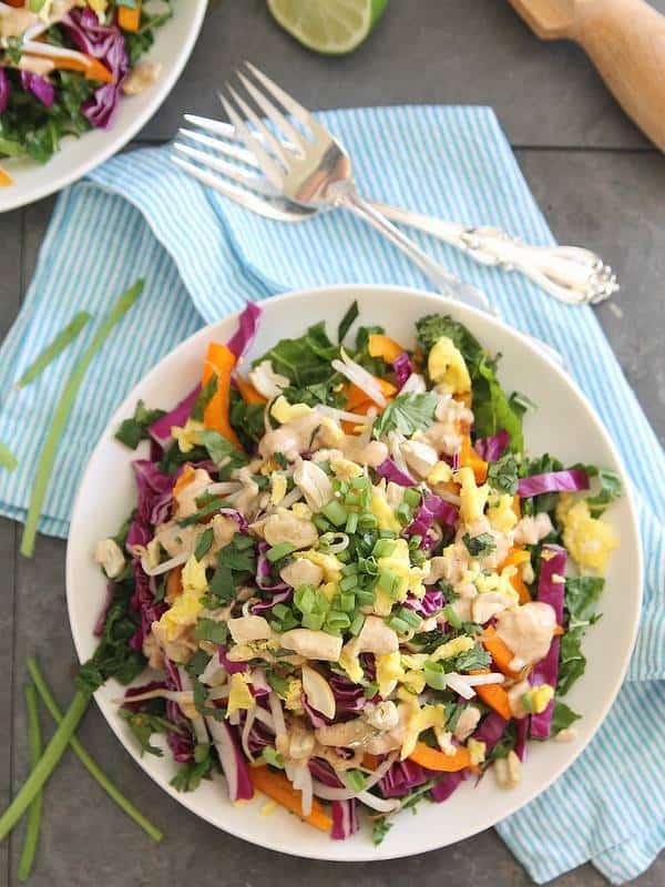 Pad Thai salad with Thai dressing and scrambled egg next to two forks.
